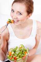 smiling woman eating fresh salad