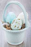 Three natural blue Easter eggs in a basket