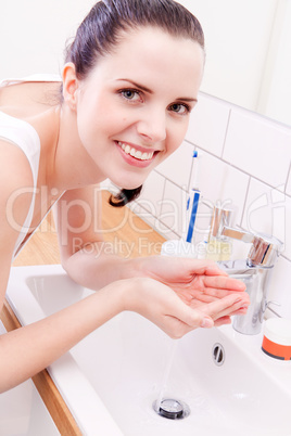 woman washing her face in bathroom