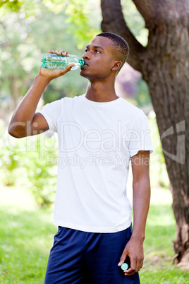 athletic african young man drinking water outdoor