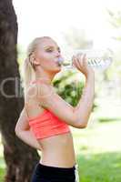 attractive young blonde woman drinking water outdoor sport
