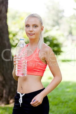 attractive young blonde woman drinking water outdoor sport