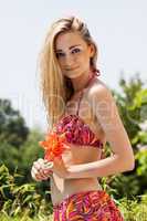 attractive young blond woman summer outdoor with flower