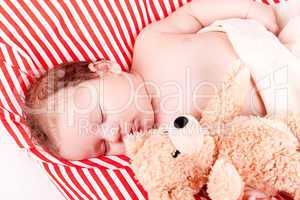 sleeping cute little baby on red and white stripes pillow