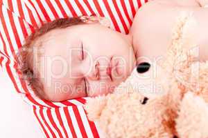 sleeping cute little baby on red and white stripes pillow