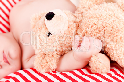 sleeping cute little baby on red and white stripes pillow