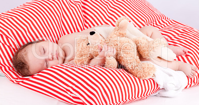 sleeping cute little baby on red and white stripes pillow