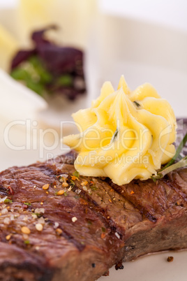 Grilled beef steak topped with butter and rosemary