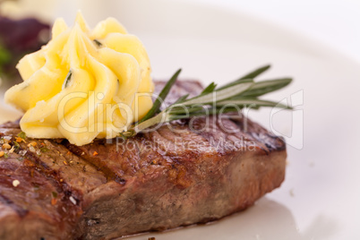 Grilled beef steak topped with butter and rosemary