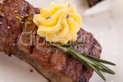 Grilled beef steak topped with butter and rosemary