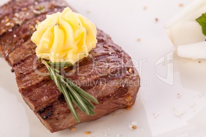 Grilled beef steak topped with butter and rosemary