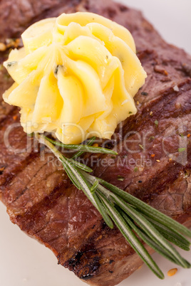 Grilled beef steak topped with butter and rosemary