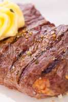 Grilled beef steak topped with butter and rosemary