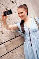 attractive young woman with smartphone camera photos outdoor