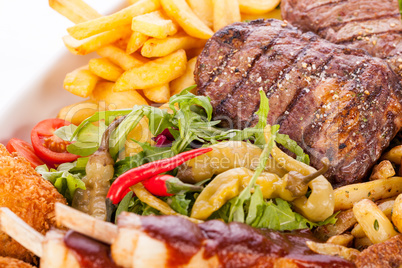 Platter of mixed meats, salad and French fries