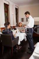 Waiter serving a couple in a restaurant