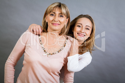 smiling middle-aged young mother and daughter