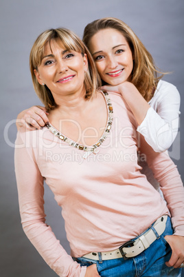 smiling middle-aged young mother and daughter