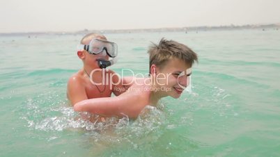 Two boys are playing and having fun in the sea