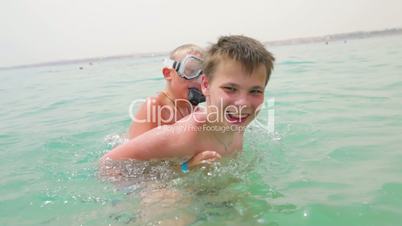 Two boys are playing and having fun in the sea