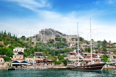 sailing boat on the background of the ruins of the old town