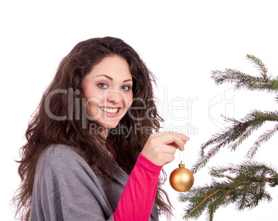 beautiful brunette woman is decorating a christmas tree