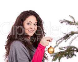 beautiful brunette woman is decorating a christmas tree