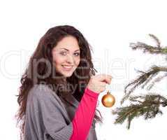 beautiful brunette woman is decorating a christmas tree