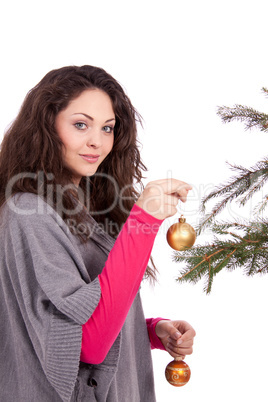 beautiful brunette woman is decorating a christmas tree