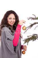 beautiful brunette woman is decorating a christmas tree