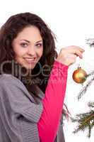 beautiful brunette woman is decorating a christmas tree