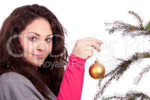 beautiful brunette woman is decorating a christmas tree