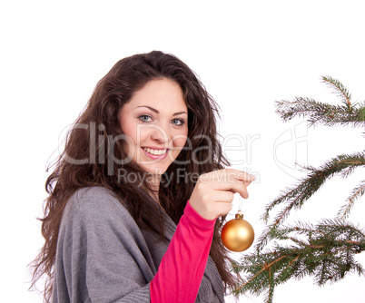 beautiful brunette woman is decorating a christmas tree