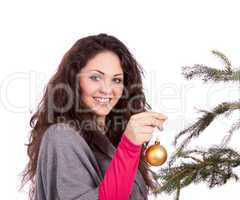 beautiful brunette woman is decorating a christmas tree