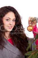 beautiful brunette woman is decorating a christmas tree