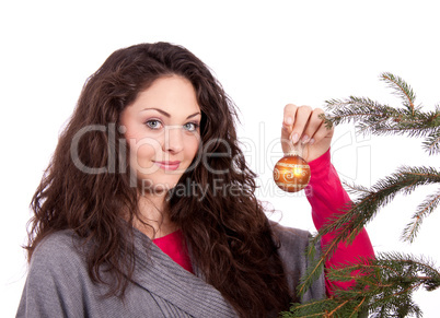 beautiful brunette woman is decorating a christmas tree