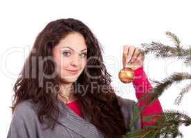 beautiful brunette woman is decorating a christmas tree