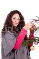 beautiful brunette woman is decorating a christmas tree