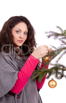 beautiful brunette woman is decorating a christmas tree