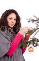 beautiful brunette woman is decorating a christmas tree