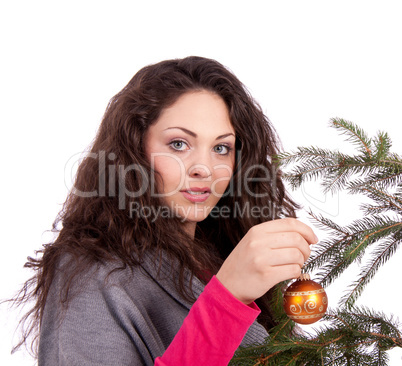 beautiful brunette woman is decorating a christmas tree