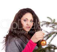 beautiful brunette woman is decorating a christmas tree