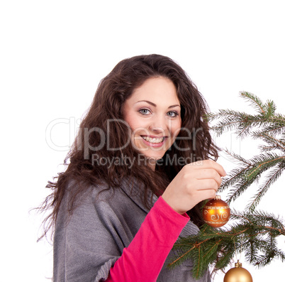 beautiful brunette woman is decorating a christmas tree