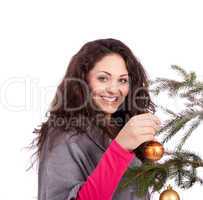 beautiful brunette woman is decorating a christmas tree