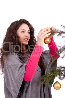 beautiful brunette woman is decorating a christmas tree