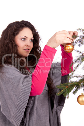 beautiful brunette woman is decorating a christmas tree