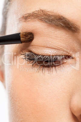 doing the makeup brown eyeshadow on beautiful eyes