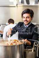 Chef stirring a huge pot of stew or casserole