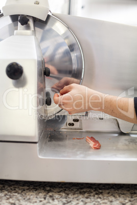 Commercial cook or chef slicing cold meat