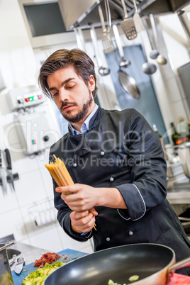 Attractive friendly chef preparing spaghetti